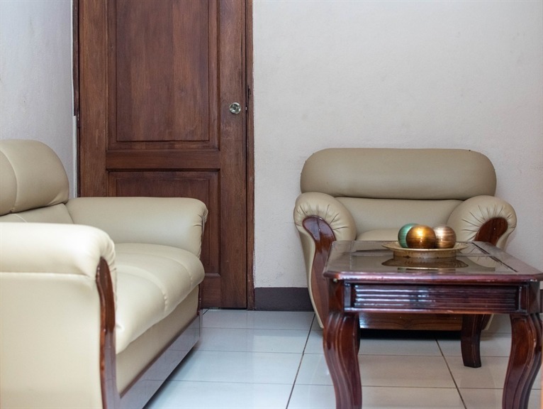 Sala de espera con sofás de cuero y mesa de madera en Funeraria El Alba Managua