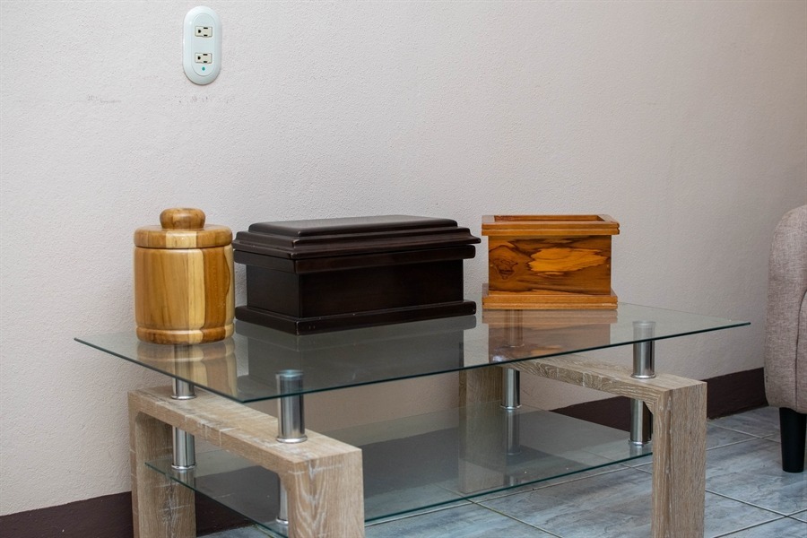 Urnas de cremación en madera exhibidas en una sala de Funeraria El Alba.