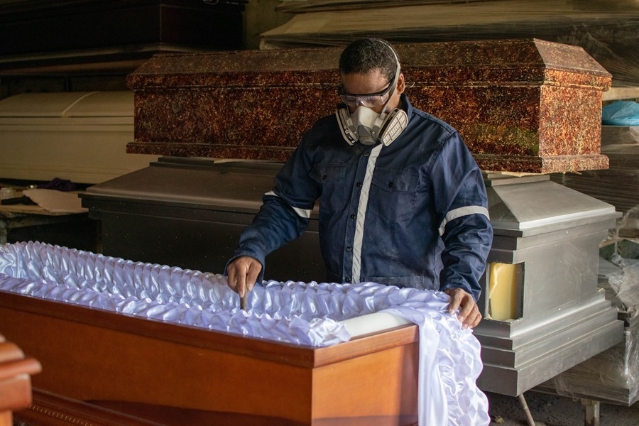 Artesano acolchando el interior de un ataúd con tela blanca en el taller propio de El Alba.