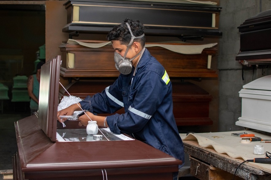 Carpintero dando acabado a un ataúd de madera en el taller artesanal de Funeraria El Alba.